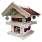 Preview: Zweistöckiges Vogelfutterhaus im alpinen Blockhaus-Stil aus hellem Holz mit rotem Schindeldach und vier aufgehängten Meisenknödeln