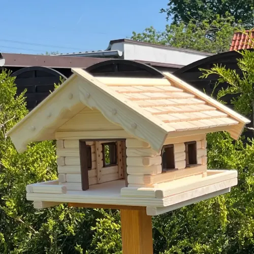vogelhaus-alm-mit-kleinen-holzschindeln-und-dunkelbraun-gebeizten-tuer-und-fensterzargen