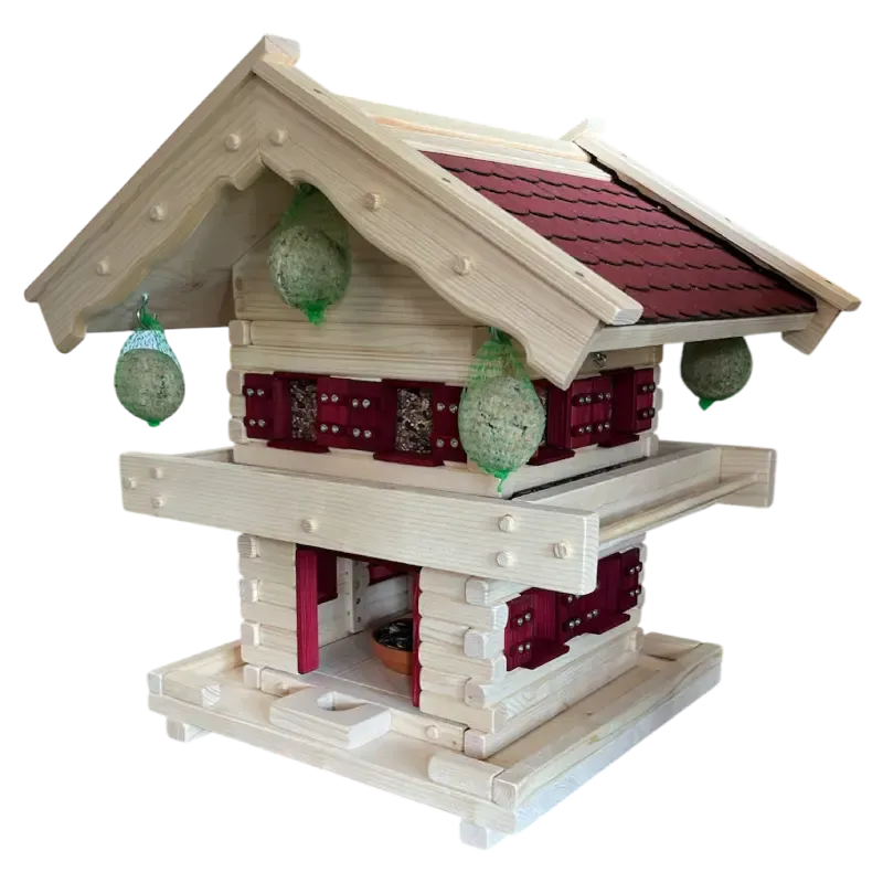 Zweistöckiges Vogelfutterhaus im alpinen Blockhaus-Stil aus hellem Holz mit rotem Schindeldach und vier aufgehängten Meisenknödeln